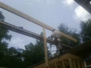 Carpenter setting a ridge beam over a new addition frame — Ice Dam Removal by Roofing Brothers in Brooker