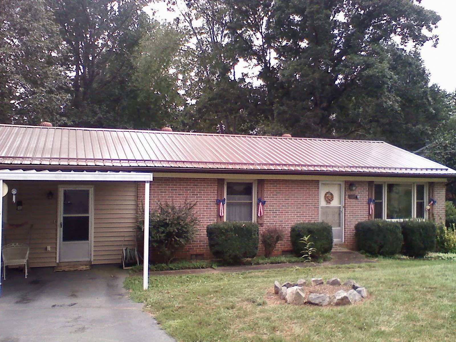 Bronze metal roof and carport on a brick ranch home — Roof Repair work by our crew in Brooker