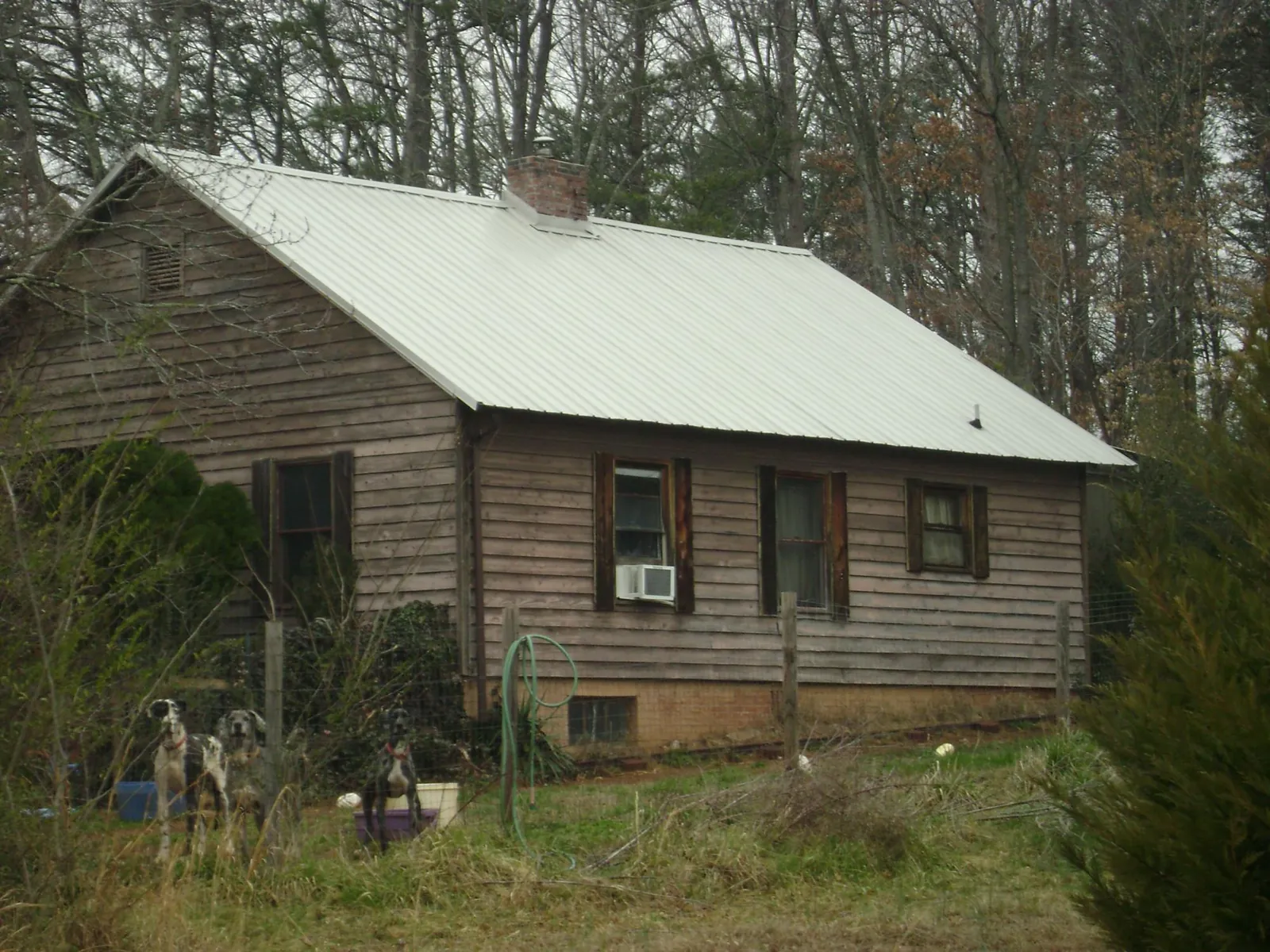 White metal roof on an old wood sided farmhouse, from a Metal Roof Installation job in Brooker